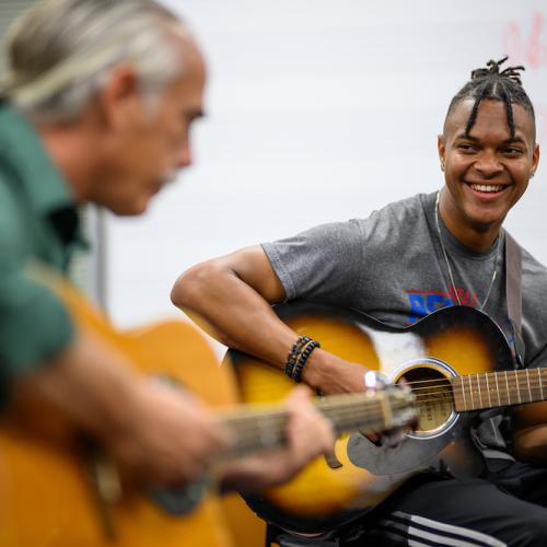 Professor teaching student guitar
